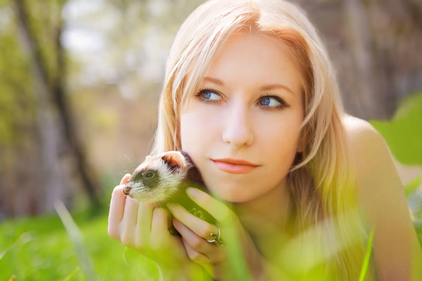 Žena drží fretku venku na jaře